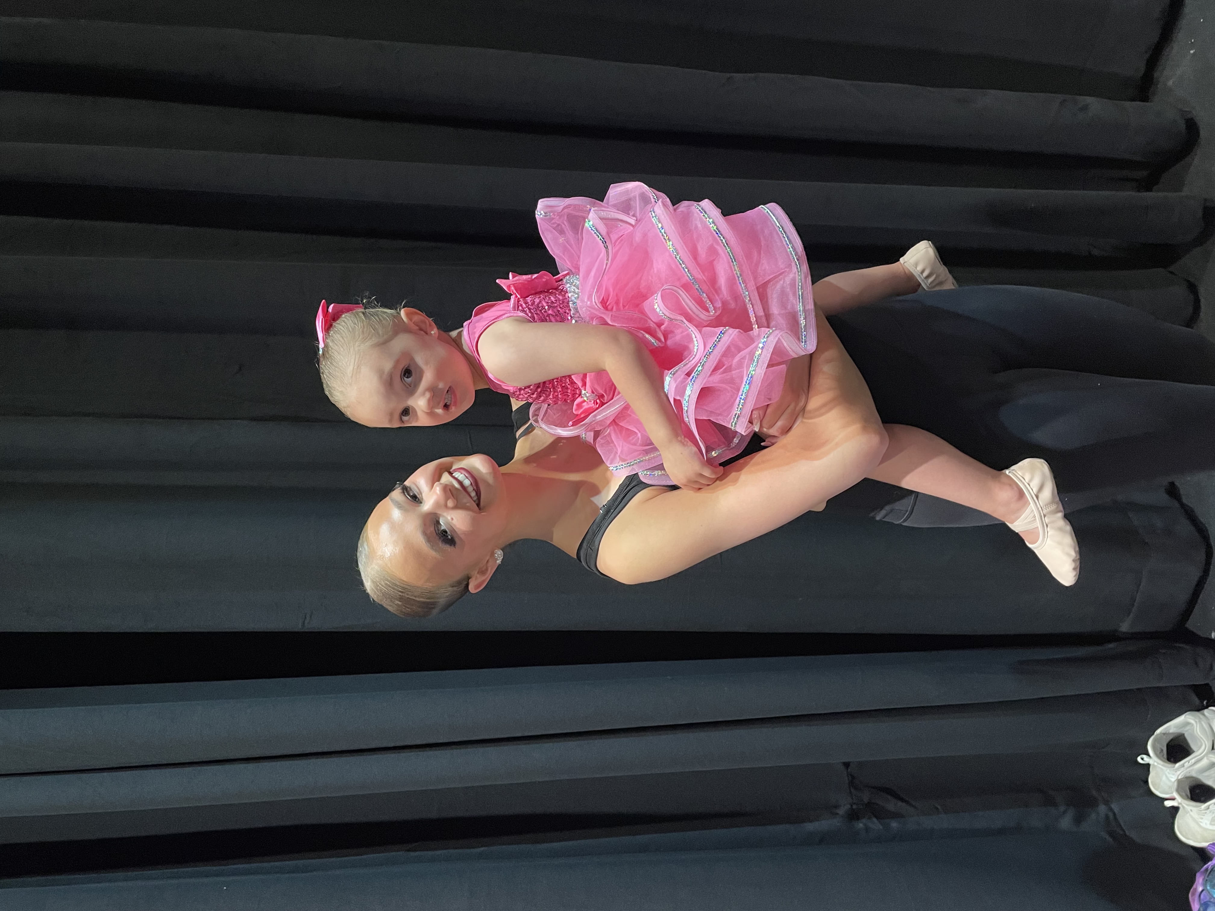 Dancers embracing on stage after a performance